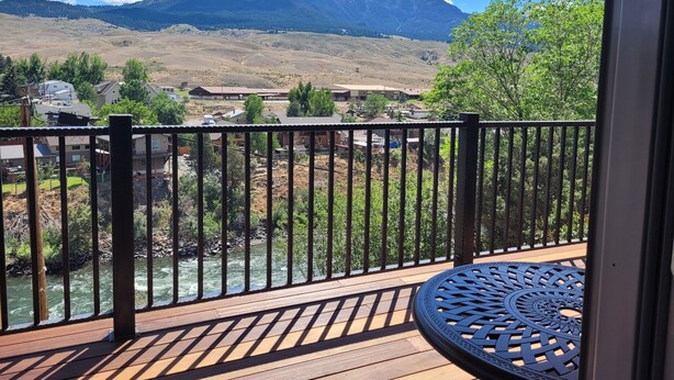 A wooden deck with a metal railing overlooking a river and mountains. - Yellowstone Beauty Overlooking Yellowstone River BRAND NEW Gardiner, MT  (Gardiner)