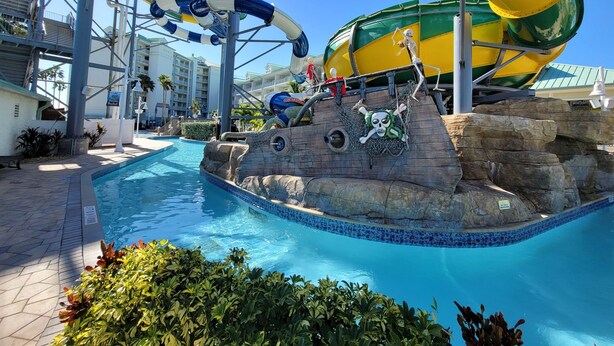 Een waterpark met een groot zwembad, glijbanen en een piratenthema gebied.