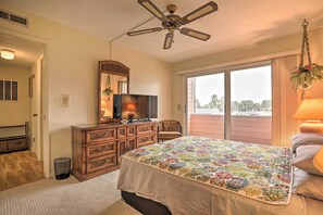 Enjoy a restful stay in this cozy room featuring a large bed, dresser, and mirror, with a window offering a view of the outdoors.