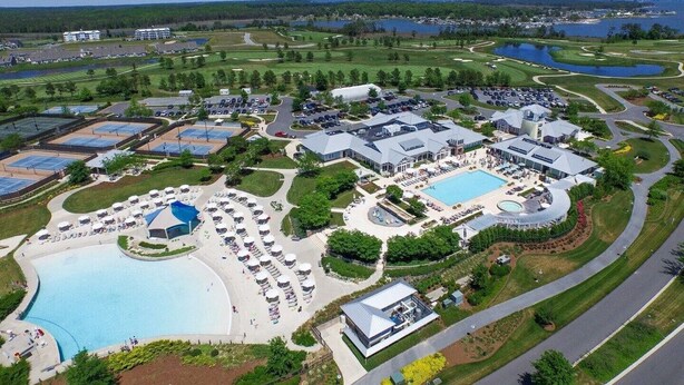 Ein Golfresort mit mehreren Pools, darunter ein großer Mittelpool, und einer gepflegten Landschaft.