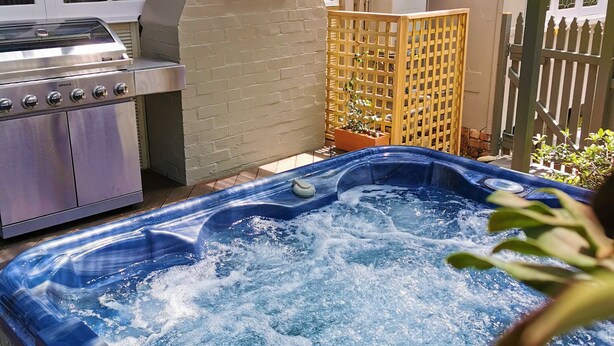 Ein Whirlpool mit Wasser, ein Grill und ein Schild mit der Aufschrift 'KATURA'.