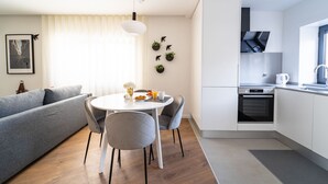 A modern kitchen with white cabinets, a built-in oven, and a stainless steel range hood.