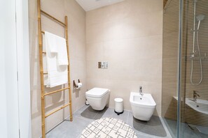 Ein modernes Badezimmer mit Toilette, Bidet und Dusche.