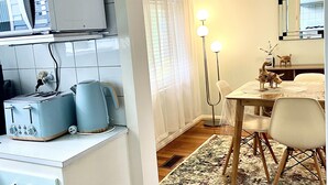 Una cocina compacta con microondas, tostadora y hervidor sobre la encimera.