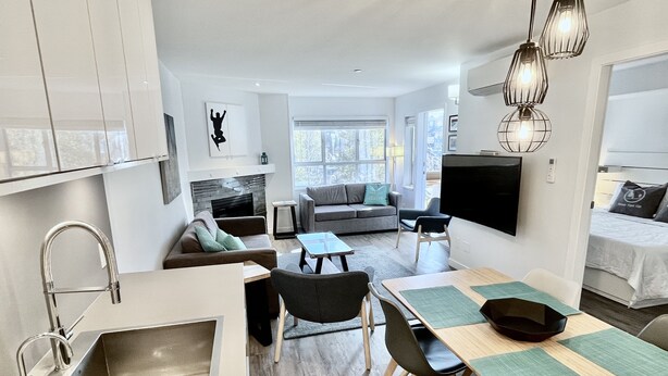 Eine moderne Küche mit integriertem Spülbecken und einem Essbereich mit Tisch und Stühlen.