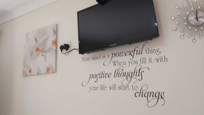 Una pared con una cita motivacional y un altavoz negro.
