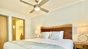 A hotel room with a large bed, a wooden headboard, two bedside lamps, and a ceiling fan. - SUNNY BRIGHT King Bed Suite Full Kitchen Free Parking Balcony BBQ Gym (Canmore)