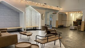 A modern lobby with a stone fireplace, wooden furniture, and a large mirror. - SUNNY BRIGHT King Bed Suite Full Kitchen Free Parking Balcony BBQ Gym (Canmore)