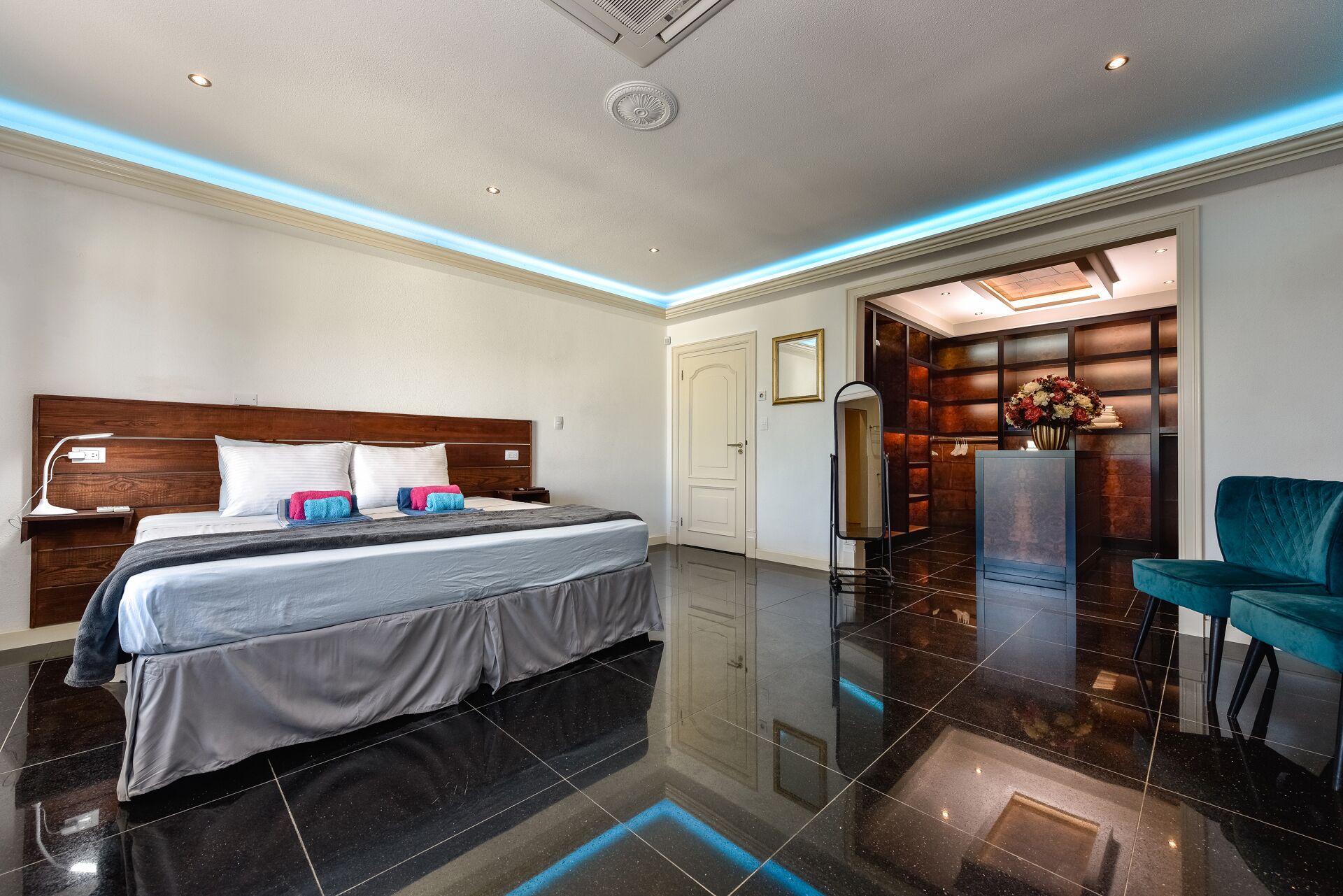 Ein modernes Hotelzimmer mit einem großen Bett, einem Schreibtisch, einem Stuhl und einem durchgegangenen Tür angedeuteten Badezimmer.
