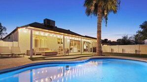 A modern house with a swimming pool, outdoor seating, and string lights. - The Dava | Free Heated Pool & Putting Green (Tempe)