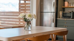 Una cocina moderna con una isla grande, electrodomésticos de acero inoxidable y una lámpara colgante.
