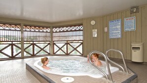 A spa with a hot tub, tiled floor, and wooden walls. - Heart of the Village. Newly renovated , modern décor throughout, Central AC just installed 2024 (Whistler)