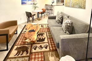 A living room with a gray sofa, a coffee table, and a rug with animal prints.