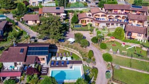 Vue aérienne d’un quartier résidentiel avec des maisons, une piscine et un petit parc.