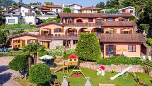 Un quartier résidentiel comprenant plusieurs maisons, une aire de jeux et un petit jardin.