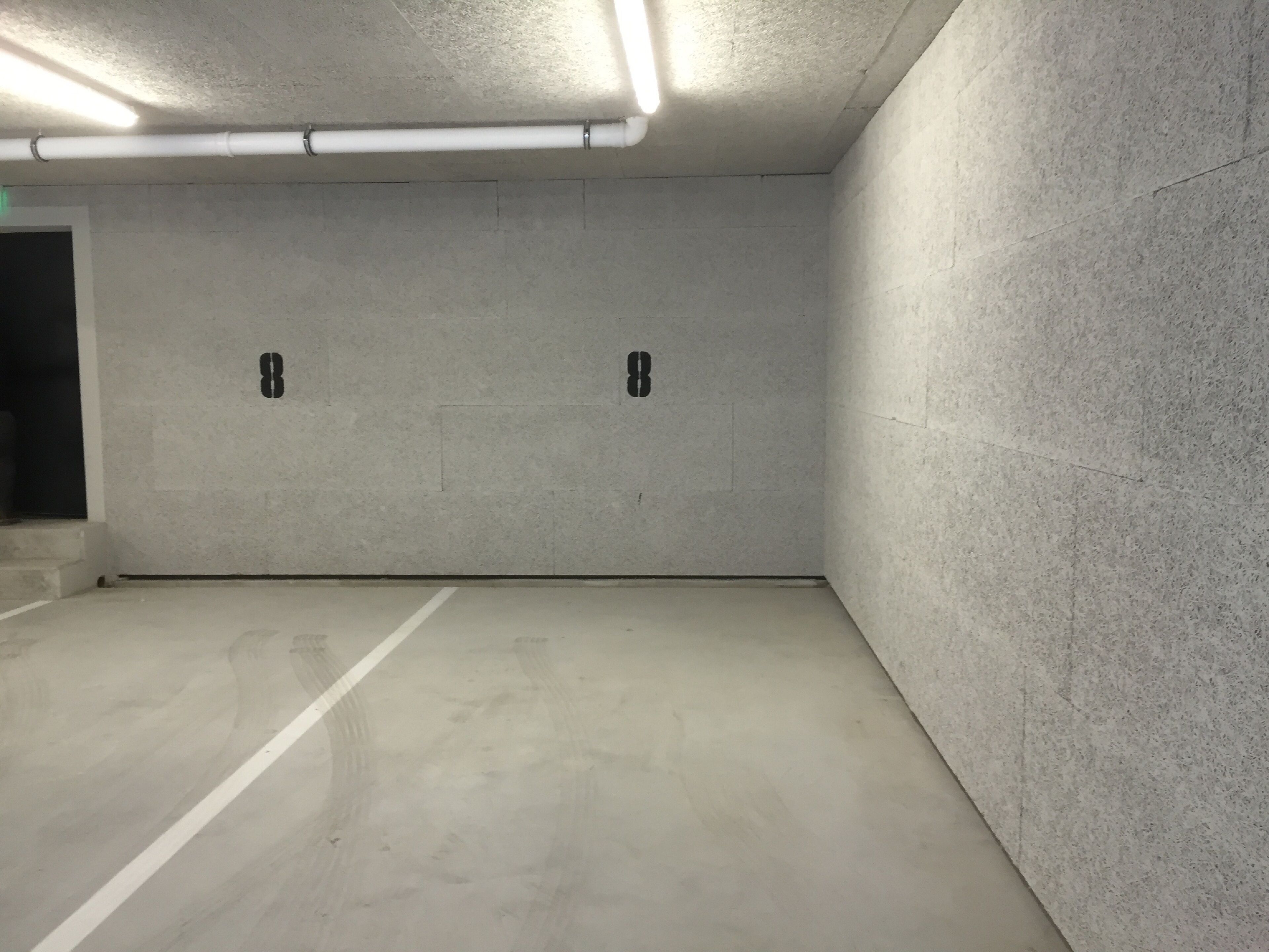 Ett parkeringsgarage med betongväggar och ett rent, enkelt golv.