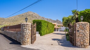 A gated entrance with stone walls and a paved path leading to a building. - Vacation Villa 'Can Serra' with Private Pool, Mountain Views, Terrace & Garden (Puerto Pollensa)