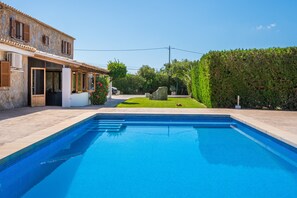 A swimming pool with a stone building in the background.
