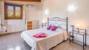A bedroom with a bed, two nightstands with lamps, a window with curtains, and a wooden ceiling. - Vacation Villa 'Can Serra' with Private Pool, Mountain Views, Terrace & Garden (Puerto Pollensa)