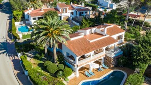 A large house with a swimming pool, multiple balconies, and a well-maintained garden. - Wonderful Villa “Villa Las Palmeras” with Sea View, Pool, Wi-Fi, A/C, Garden & Terrace (Binibequer)