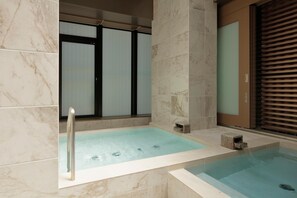 A modern spa area with a hot tub, marble tiles, and a sliding glass door. - Candeo Hotels Kyoto Karasuma Rokkaku (Kyoto)