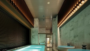 Un spa moderno con piscina central, dos tinas grandes y un diseño minimalista.