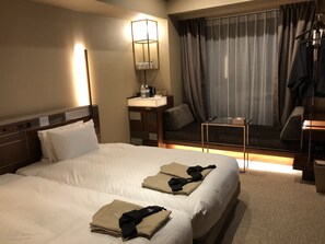 A hotel room with two beds, a desk, a chair, a mirror, and a window with curtains. - Candeo Hotels Kyoto Karasuma Rokkaku (Kyoto)