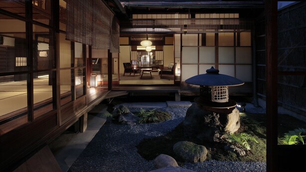 Un interior en estilo tradicional japonés, con suelo de tatami, una mesa baja y un farol.