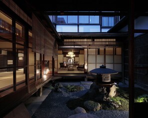 Un interior en estilo tradicional japonés, con suelo de tatami, una mesa baja y un farol.