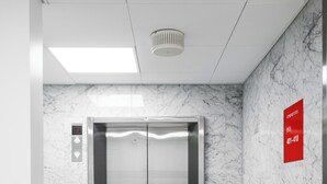 An elevator with a digital control panel, marble walls, and a red emergency contact sign. - Omena Hotel Turku Kauppiaskatu (Turku)