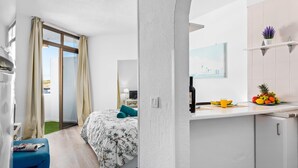 A modern hotel room with a bed, a small kitchenette, a bathroom, and a view of the city. - 419 Beautiful Summerland Studio, Wi-Fi sat.Tv (Los Cristianos)