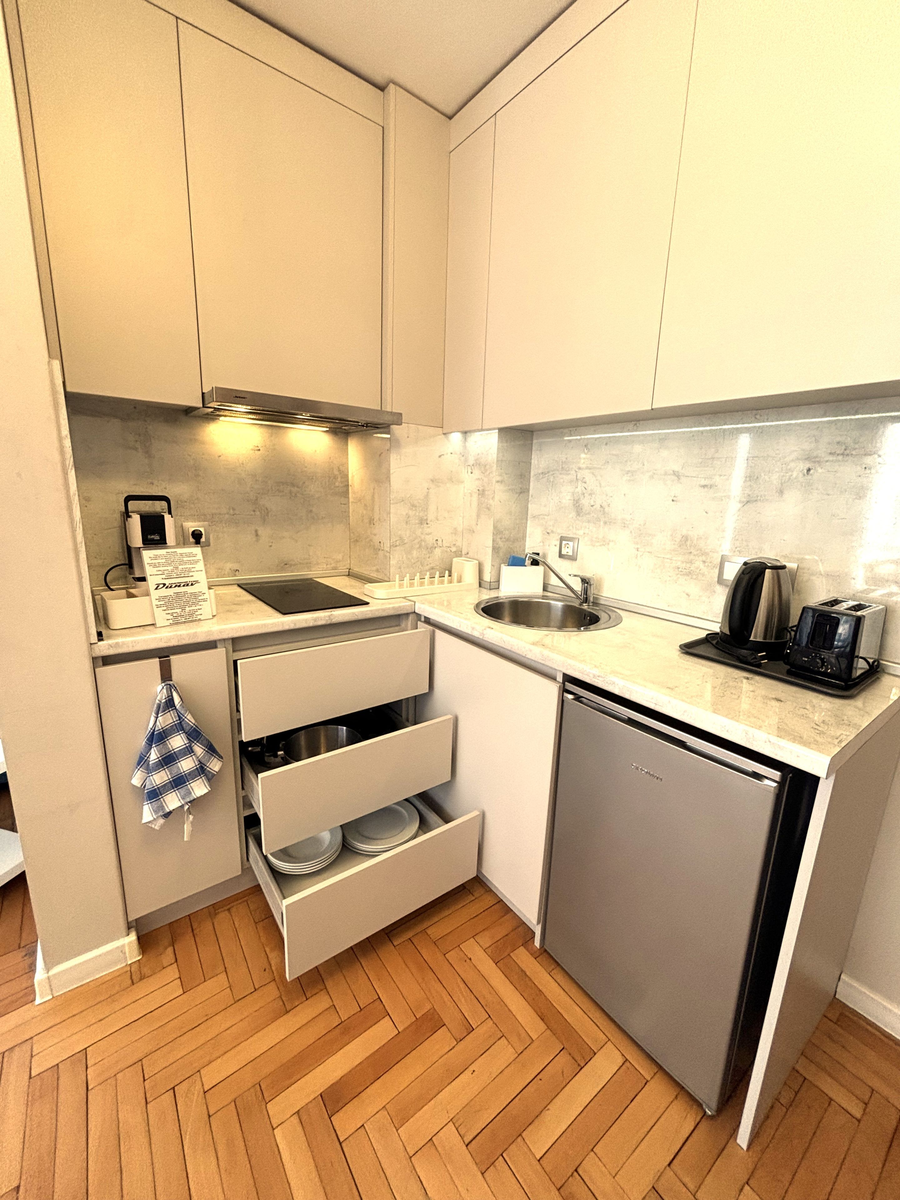 A compact kitchen with a dishwasher, a sink, and a toaster.