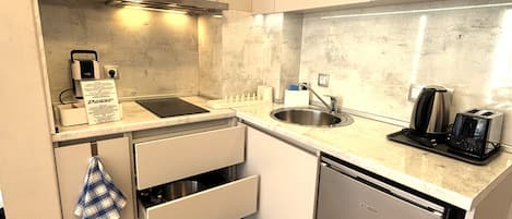 A compact kitchen with a dishwasher, a sink, and a toaster.