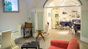 Ein geräumiges Zimmer mit Essbereich, einem roten Sofa und einem Tisch mit einer Lampe.