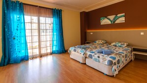 A bedroom with two beds, a large window with curtains, a painting on the wall, and a bench. - 15min walk from Albufeira Old Town, Free wifi, Air Conditioning (Albufeira)