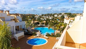 A rooftop swimming pool with lounge chairs, surrounded by a white building and palm trees. - 15min walk from Albufeira Old Town, Free wifi, Air Conditioning (Albufeira)