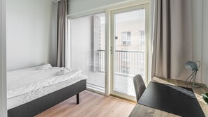 Een moderne hotelkamer met een bed, een bureau en uitzicht op het balkon.