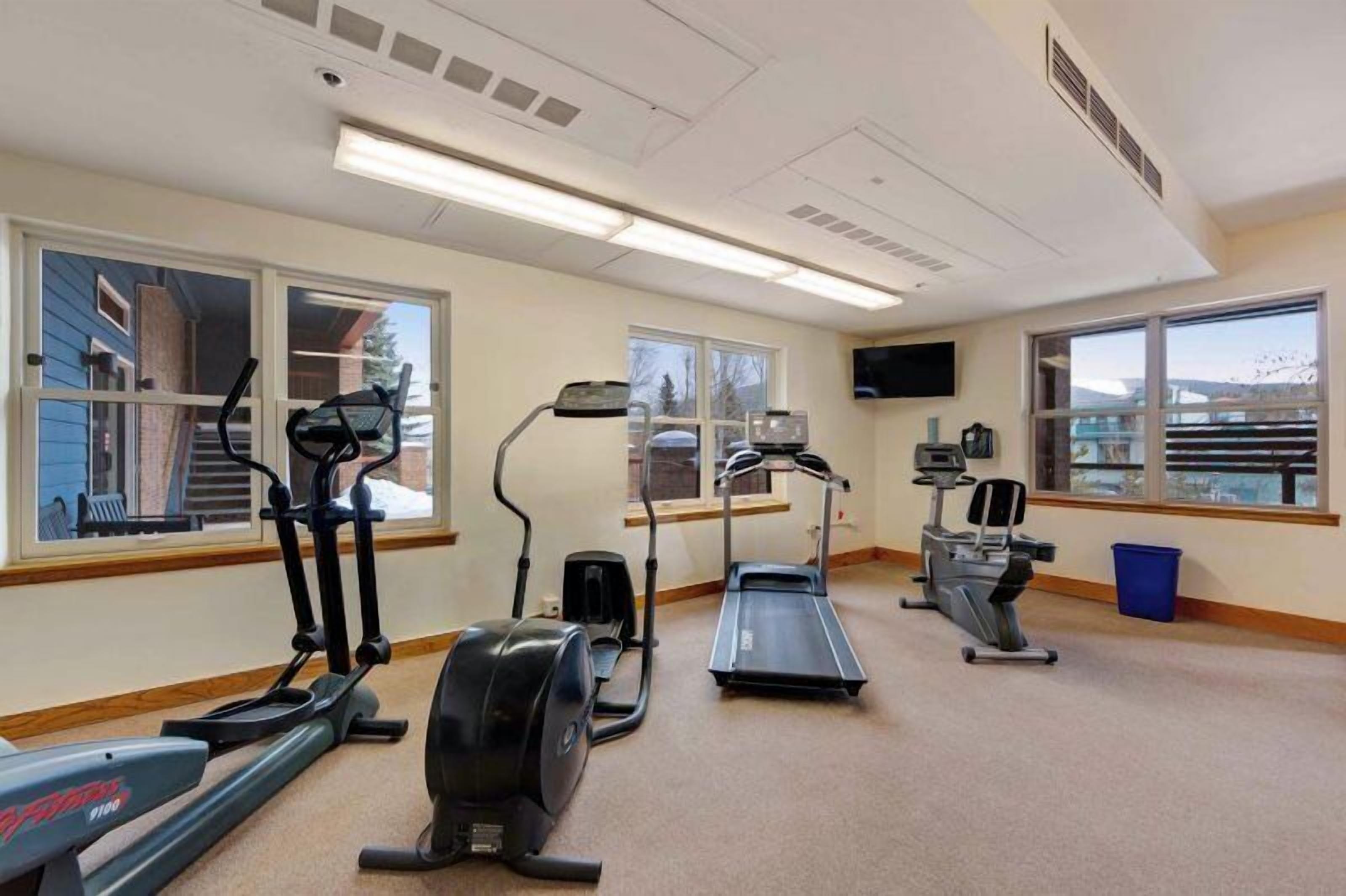 A gym with treadmills, ellipticals, and a stationary bike.