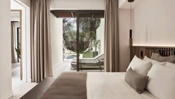 Un dormitorio moderno con una cama grande, vistas a un jardín y una puerta corrediza de vidrio que da a un espacio exterior.