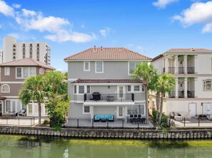 A two-story building with a balcony and a covered outdoor seating area. - Sandprint By The Sea - Private Beach Access, Community Pool, Free Beach Service! (Destin)