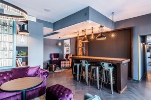A modern interior with a bar area, seating, and a bookshelf.