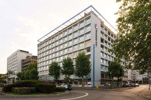 A multi-story hotel with a modern design, featuring a prominent logo on the facade.