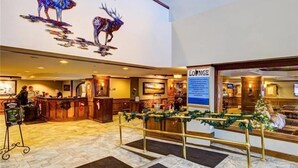 A lobby with a reception desk, a sign for the lounge, and a large wall mural of deer. - 2 Bedroom Ski in Condo Only One Block From Historic Downtown, Shopping, Restaurants and Entertainment (Breckenridge)