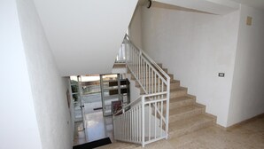 A staircase with white railings leading to an upper floor. - Apartment Ala (Rovinj)