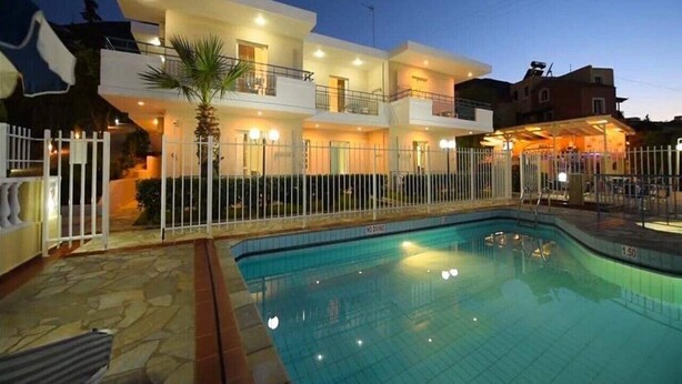 Un edificio moderno de dos pisos con una piscina al frente.
