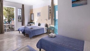 Habitación de hotel con dos camas, un escritorio pequeño, una silla y vistas al exterior.