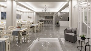 Une salle à manger spacieuse et moderne, avec de hauts plafonds, un lustre et un bar en arrière-plan.