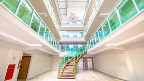 A multi-level interior with a central staircase, glass railings, and a decorative ceiling light fixture.