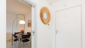 Ein Essbereich mit Tisch, Stühlen, einem Spiegel und einer Wanddekoration.