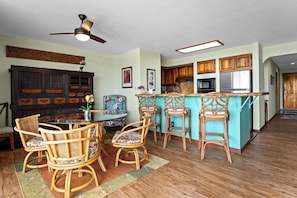 Enjoy meals in the kitchen and dining area, featuring a round table and wicker chairs.